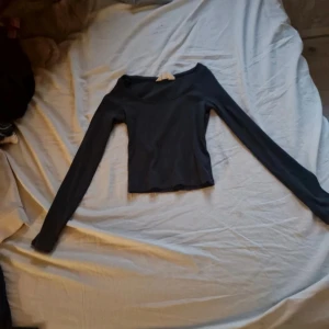 Svart croppad långärmad topp H&M - Säljer en svart croppad långärmad topp från H&M med rundad halsringning. Enkel och stilren design som är lätt att matcha med olika outfits. Mjuk och stretchig kvalitet som sitter snyggt på kroppen.