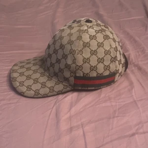 Gucci keps äkta - Säljer en snygg keps från Gucci i beige med klassiskt GG-monogram över hela kepsen. Den är 100% äkta om du har frågor kör på 