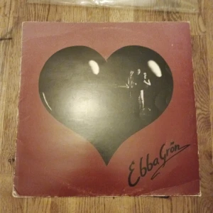 Ebba Grön - Kärlek & Uppror - Första Press 1981 - Vinyl (LP) - Vinylskiva med ikoniskt hjärta på omslaget från Ebba Grön. Perfekt för dig som gillar svensk punk och vill ha en klassiker i samlingen. Innehåller texthäfte med låttexter och bilder på bandet. En kultfavorit för unga vuxna och musikälskare.