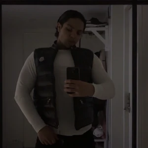 Svart dunväst från Moncler - Säljer en svart, glansig dunväst från Moncler med klassisk logga på bröstet. Västen har dragkedja framtill och två fickor med dragkedja. Perfekt för lager-på-lager och riktig fräsch! Passa på nu för hösten närmar sig ! M passar S  västen är ett halvt år gammal men spar samt använd👍