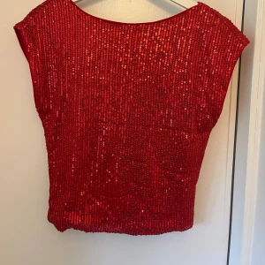 Röd paljett topp från Vero Moda❤️ - Säljer en glittrig röd topp från Vero Moda i storlek S. Enbart testad med prislapp kvar. Toppen har en urringning i ryggen och den är täckt av röda paljetter som ger ett riktigt festligt intryck. 