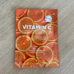 Vitamin C Hydrating Sheet Mask - Fuktgivande sheet mask med vitamin C från Makeup Mekka. Masken är orange med citrusmotiv och passar alla hudtyper. Innehåller återfuktande och lugnande ingredienser för en fräsch känsla. Perfekt för dig som vill boosta huden snabbt.