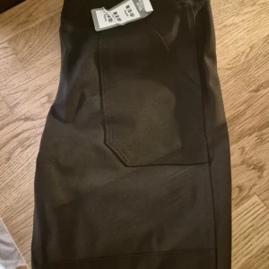 Svarta tights från Carhartt M - Svarta tights från Carhartt i storlek M. Byxorna har flera praktiska fickor, robust sömnad och klassisk Carhartt-logga på bakfickan. Fitted passform och tillverkade i slitstarkt material.