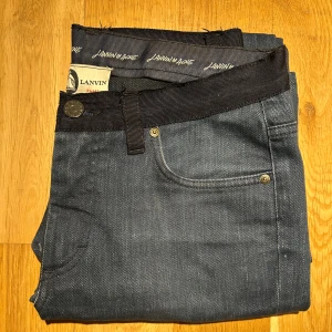 Lanvin x Acne jeans - Blåa Lanvin x Acne jeans med svarta detaljer vid bältet. Storlek 30/30. Riktigt feta som är i mer eller mindre 10/10 skick. Inga riktiga defekter, möjligtvis lite smuts på dem.