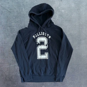 Hollister Hoodie - Sjukt fet hoodie från Hollister i ett bra skick. Tröjan är Xs men passar även S, se mått. Längd: 61/62, bredd: 49, arm: 53. Modellen på bilden är ungefär 175, 59kg. Skriv vid frågor