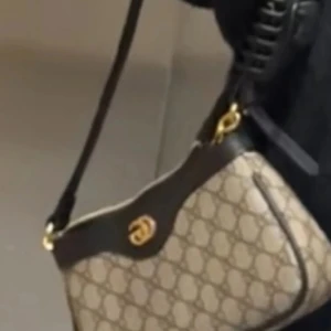 Gucci axelväska med monogram - Hej säljer min Gucci väska den är inte äkta men väl bra kvalité inte haft den sålänge nån månad. Finns kedja med och går att ta bort om man vill. 