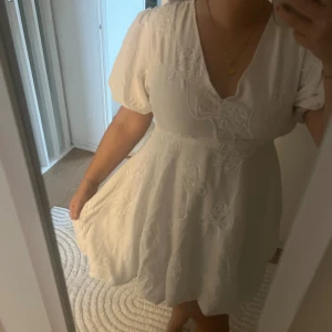 Vit kortklänning med broderade blommor - Jättefin klänning från min student köpt utomlands, säljer för 250, storlek M