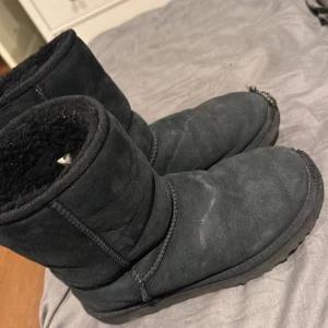Svarta UGG boots i mocka - Mysiga svarta UGG boots i mjuk mocka med fluffigt foder på insidan. Nypris är 2750 kr. Dom har lite missfärgning av regn men inget man tänker på, dock även blivit uppskrapade där fram vid tån som man ser på bilderna därav priset