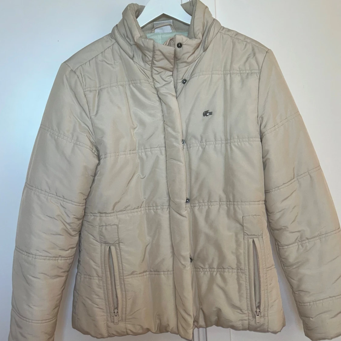 Beige pufferjacka från Lacoste