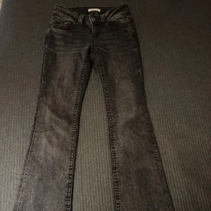 Svarta bootcut jeans från ginatricot - Snygga svarta jeans från Perfect Jeans i bootcut-modell. Jeansen har klassisk femficksdesign, markerade sömmar och knäppning fram. Materialet är jeans med en lätt tvättad look och passformen är normal. Perfekta för dig som gillar en tidlös stil med lite extra edge.