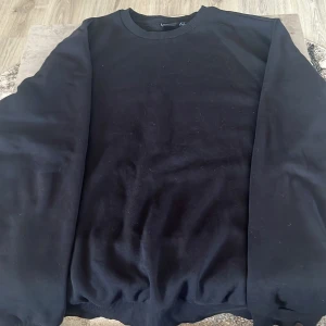 Svart sweatshirt från Only & Sons - En stilren svart sweatshirt från Only & Sons med rund hals och ribbade muddar. Tröjan är långärmad och har en klassisk, loose passform. Materialet är mjuk bomull och polyester, perfekt för chill dagar. Enkel design utan mönster eller detaljer. Använd 2 ggr!