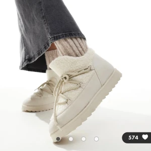 Asos Beige boots med snörning och teddy Stl 38 - Säljer ett par ASOS beige boots med snörning och platt sula. Skorna har en mysig teddyfoder på insidan och utsidan, Stl 5 / 38 använda ngt ggr förra vintern. Fint skick men självklart lite smuts på ljusa boots;))