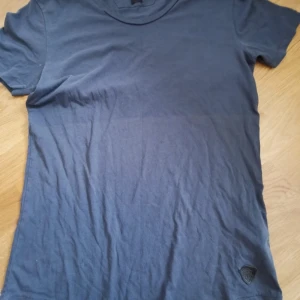 Blå t-shirt från Tiger of Sweden - Snygg blå t-shirt från Tiger of Sweden Jeans med rund hals och diskret logga nertill. Tillverkad i mjuk bomull och har en klassisk passform med korta ärmar. Perfekt till jeans eller shorts för en clean look.