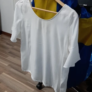 Vit blus från Massimo Dutti - Stilren vit blus från Massimo Dutti med rund halsringning och långa ärmar. Tillverkad i ett lätt och luftigt material som ger en avslappnad men ändå chic look. Perfekt att matcha med jeans eller kjol för en trendig outfit.