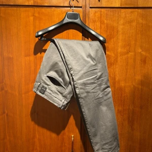 Replay gråa jeans - Säljer ett par grå Replay Hyperflex jeans med klassisk rak passform och snygga detaljer som myntficka och diskret Replay-logga bak. Byxorna har bälteshällor och är tillverkade i ett stretchigt bomullsmaterial som ger extra komfort. Perfekta för en clean och stilren look. Köpta på Johnells för 1800kr. Använda en gång