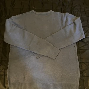 Grå stickad tröja med rund hals - En enkel och stilren grå stickad tröja från Selected Homme. Tröjan har rund halsringning, långa ärmar och ribbade muddar vid ärmslut och nederkant. Perfekt för lager-på-lager under kyliga dagar.