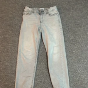 Ljusgrå jeans från Jack & Jones, 158 - Säljer ett par ljusgrå jeans från Jack & Jones i storlek 158, passar dig som är runt 13 år. Klassisk femficksmodell med raka ben och snygga detaljer. Perfekt för dig som gillar stilrena och enkla jeans med modern vibe. 150 kr men pris kan diskuteras 