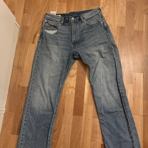 Levi's 551z ljusblå jeans W32 L32 - Ljusblå Levi's 551 jeans med klassisk femficksdesign och raka ben. Jeansen har en snygg tvättad look och detaljer som synliga nitar och läderpatch bak. Perfekta för en avslappnad streetstil.
