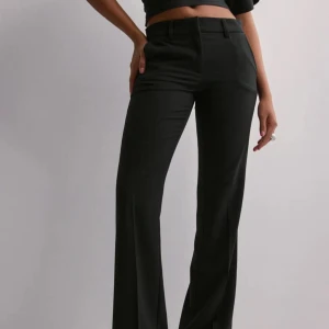 Lågmidjande kostymbyxor Nelly - Säljer ett par fina lågmidjande kostymbyxor från Nelly klassisk rak modell. Noppriga.