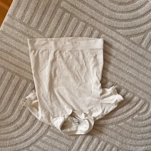 Ribbad vit t-shirt från Zara - Snygg ribbad t-shirt från Zara i vitt med diskreta tunna ränder. Modellen är kortärmad och har en klassisk passform med bredare kant nertill och vid ärmslut. Perfekt till jeans eller kjol för en clean look.