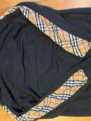 Svart tröja  - En tröja med fint mönster på armarna, passar stl M