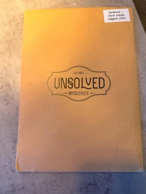 Mordspel, Sekten – Den enda vägen - Ett spännande och utmanande mordspel där du får lösa en svår utredning på 2-3 timmar. Perfekt för dig som gillar deckare, thrillers och att klura ut gåtor tillsammans med vänner. Innehåller autentiska ledtrådar och bilder för en verklighetstrogen upplevelse. På bild nr 2 är den lite trasig i själva kuvertet men det är inget som påverkar spelet! Har försökt återskapa spelet så mkt som möjligt så det ser typ nytt ut nu! 