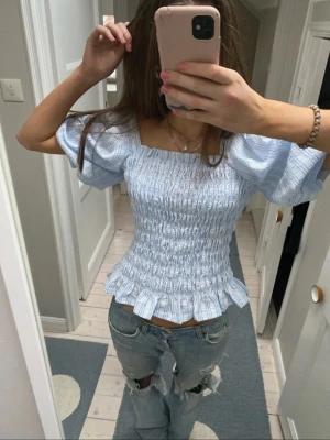 Rutig topp med puffärm - Blåvit mönstrad blus med smock och puffärmar. Har gjort ett stygn i ryggen för bättre passform. Mycket bra skick! Sitter som S/M💙