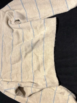 Beige croppad stickad tröja Shein - Säljer en beige croppad stickad tröja från Shein i storlek S. Tröjan har ljusblå ränder och rund hals. Den är långärmad och har en loose passform som ger en chill vibe. Perfekt för dig som gillar enkla men snygga detaljer.