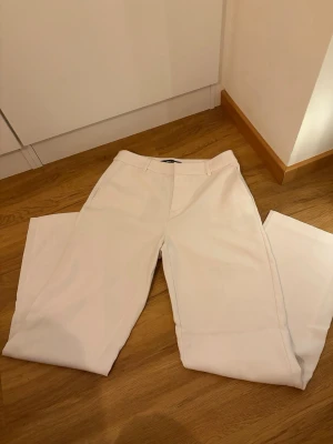 Gina Tricot - Lågmidjade vita kostymbyxor, raka i modellen. Har använts en gång. 