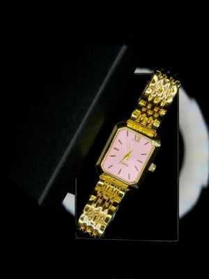 Quartz Pink Edition *Helt ny* - Quartz Pink Edition, helt ny och oanvänd. Den här modellen sticker ut med sin mjuka rosa urtavla som kontrasterar snyggt mot den guldfärgade boetten och länken. Färgen ger ett feminint men samtidigt stilrent intryck – inte för stark, utan elegant och balanserad. Den rektangulära formen tillsammans med romersk XII ger klockan en klassisk touch med modern känsla.  En perfekt klocka för dig som vill ha något som känns personligt, trendigt och elegant, och som funkar lika bra till vardags som till f