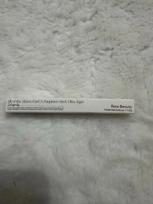 Rare Beauty ögonskuggsstick Integrity - Säljer en ögonskuggsstick från Rare Beauty i färgen Integrity. Ultra-krämig och multifunktionell stick som är lätt att applicera och blanda. Förpackningen är vit och stilren, innehåller 1,3 g produkt. Perfekt för att skapa snygga ögonlooks.