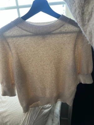 Beige stickad kortärmad tröja Vero Moda - Säljer en beige stickad tröja från Vero Moda i storlek XS. Tröjan har korta ärmar, ribbad rund hals och är mjuk i materialet. Perfekt för dig som gillar enkla och stilrena plagg med en chill vibe.