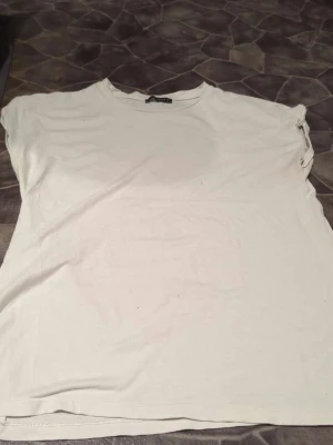 Vit t-shirt från Rut&Circle XS - Enkel och stilren vit t-shirt från Rut&Circle i storlek XS. T-shirten har korta ärmar och rund halsringning. Perfekt basplagg till garderoben och lätt att matcha med allt. Tillverkad i mjukt bomullsmaterial.