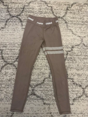 Beiga Leggings Stronger  - Säljer dessa fina beiga leggings från Stronger i storlek S. Jättefint skick och använda några gånger. Tycker inte att de passar mig så bra. Nypris: 699! Säljer för 250kr pga så fin standard. Pris kan diskuteras! 