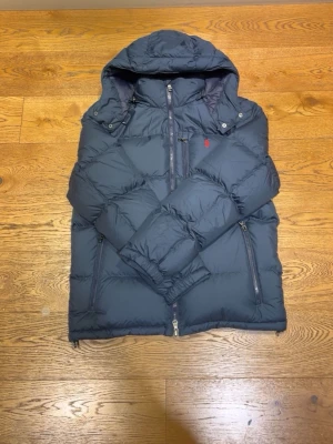 Mörkblå pufferjacka från Polo Ralph Lauren - Säljer en mörkblå pufferjacka från Ralph lauren, den är prefekt för kalla dagar men funkar också under vår/höst varan kostar vid nypris runt ca 6500, jag säljer jackan för den var för liten och jag tog av taggen och kan inte lämna tillbaka den.  Jag har självklart kvittot och fråga om du har några fler frågor.