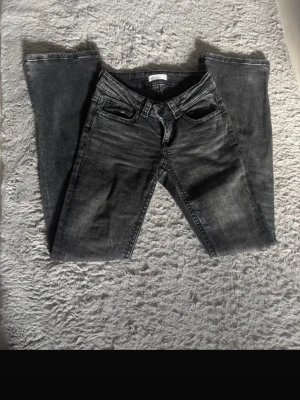 Perfekt svarta bootcut jeans, stl 34 - Svarta jeans från Perfect Jeans i bootcut-modell med klassisk femficksdesign och snygga detaljer på bakfickorna. Jeansen har en mörk tvätt och är tillverkade i jeansmaterial med normal passform. Perfekt för dig som gillar en tidlös look.