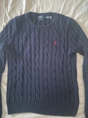 Mörkblå kabelstickad tröja Polo Ralph Lauren - Snygg mörkblå kabelstickad tröja från Polo Ralph Lauren i storlek M, skulle säga att den även passar till S. Använd fåtal gånger och är i mycket bra skick! Bara att meddela vid frågor☺️