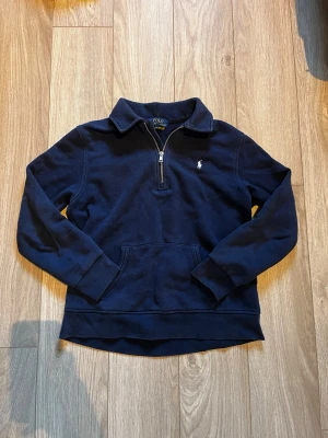 Ralph Lauren halv zip - Marinblå tröja från Polo Ralph Lauren. Tröjan är använd ett fåtal gånger. Jag köpte den i butik för ungefär 1,5 månader sedan.