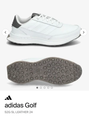 Adidas Golf S2G SL Läder golfskor - Helt nya i kartong. Vita golfskor från Adidas med grå detaljer och klassiska ränder på sidan. Skorna är i nån form av läder, har snörning och en slitstark sula med grepp för golfbanan. Nypris 1500kr. Stl 46, Uk 11 us12