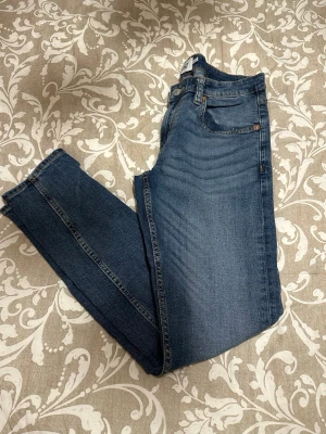 Blå jeans från Lager 157, modell Rocket - Snygga blå jeans från Lager 157, modell Rocket, i storlek M. Klassisk femficksdesign med gul kontrastsöm och knappstängning. Jeansen har en smal passform och är tillverkade i jeansmaterial med lätt tvättad look. Perfekt för dig som gillar stilrena och bekväma jeans.