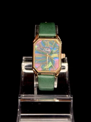 Botti Aurora Emerald *Helt ny* - Elegant klocka med guldfärgad boett, rektangulär urtavla med skimrande aurora-effekt och grönt läderarmband. Unik design som sticker ut och ger en lyxig, trendig känsla. Quartz-urverk. *Helt ny*