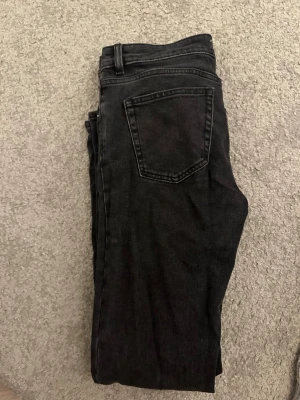 Svarta bootcut jeans från 157 - Säljer ett par svarta jeans från 157 med bootcut-snitt och låg midja. Jeansen har klassiska bakfickor och är gjorda i jeansmaterial. Perfekt för dig som gillar en avslappnad och stilren look.