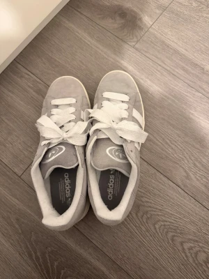Grå Adidas campus 00’s - Säljer ett par grå adidas campus 00’s. Storlek 43 1/3. Aldrig använda, endast testade, i perfekt skick