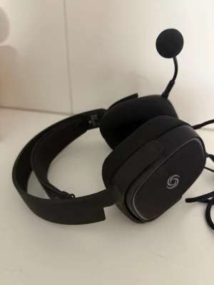 NOS H-500 Ultralight Headset - NOS H-500 Ultralight Headset med mikrofon, kabelanslutning och USB. Bekväm design med mjuka öronkuddar och justerbar mikrofon. Passar perfekt för gaming eller arbete. Oanvänt 
