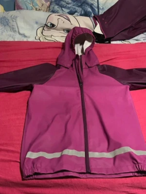 Kids Waterproof Rain Set - Waterproof rain set from Amywear Active in a beautiful purple color. Jacket and pants are from the same set but different sizes, which is common when kids grow at different speeds. Jacket: Size: 134/140 Zip-up with hood Reflective details Lightweight and comfortable Pants: Size: 122/128 Elastic waist and leg openings Adjustable foot straps Reflective details Perfect for outdoor play, school, preschool, autumn and rainy days 🌧️ Used but in good condition – no holes or major damage. Please note the