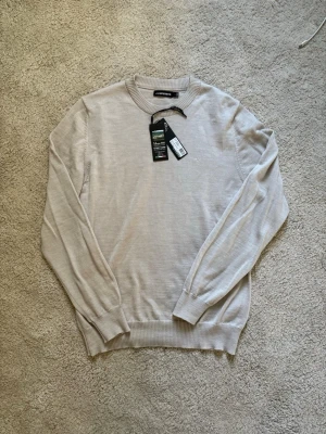 Ljusbeige stickad J. Lindeberg tröja - Helt ny stickad J.Lindeberg tröja, nypris 1400kr säljer den nu för endast 749kr. Skriv vid frågor!