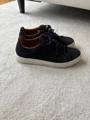 Mörkblåa mocka sneakers - Snygga mörkblåa mocka sneakers från Strömberg. Använda två gånger så i väldigt fint skick. Nypris 2299kr