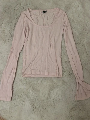 Ljusrosa långärmad topp Gina Tricot - Supersöt ljusrosa långärmad topp från Gina Tricot i storlek XS. Toppen har en rundad urringning och är gjord i mjuk bomull. Ärmarna har en lätt utsvängd detalj vid slutet som ger en extra touch.