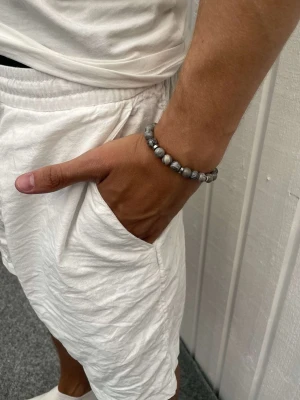 STENARMBAND 8mm - Ljusgrå - Snyggt STENARMBAND från Montore. 8mm pärlor med metalldetaljer. Vid fler frågor eller funderingar, hör av dig!