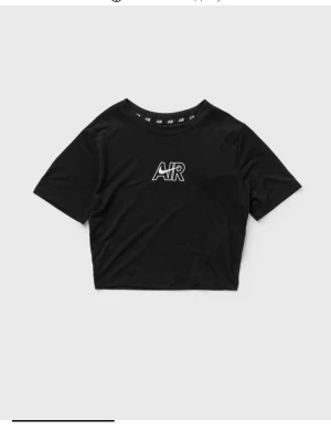 Svart croppad Nike topp t-shirt - Säljer en svart croppad topp från Nike med AIR-tryck framtill. Har använt den bara två gånger så den är som ny. T-shirten har korta ärmar, rund halsringning och är i slim fit-modell. Tillverkad i mjuk bomull som känns skön mot huden. Perfekt för en sportig och trendig look.
